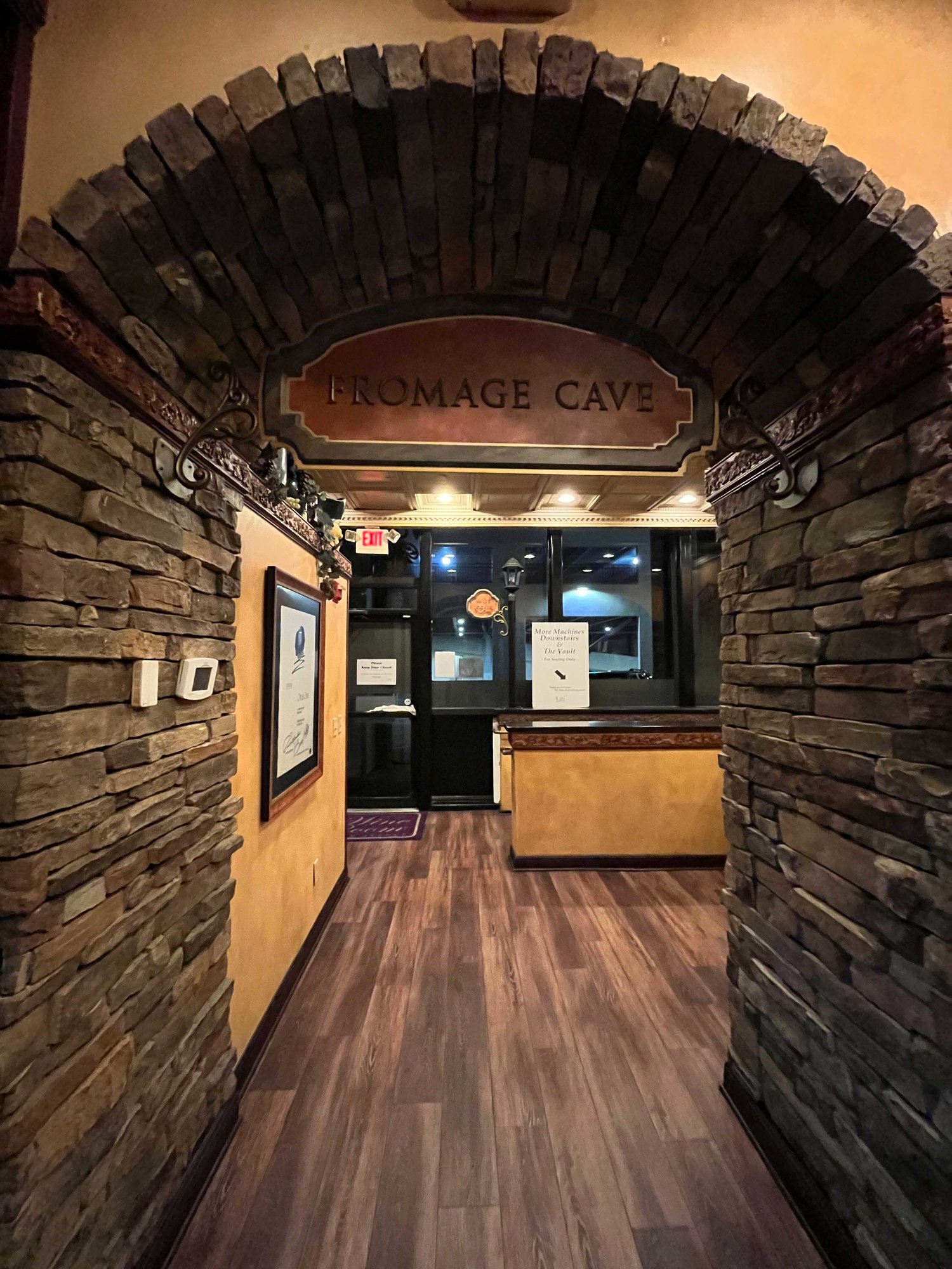 doorway with stones and sign with fromage cave